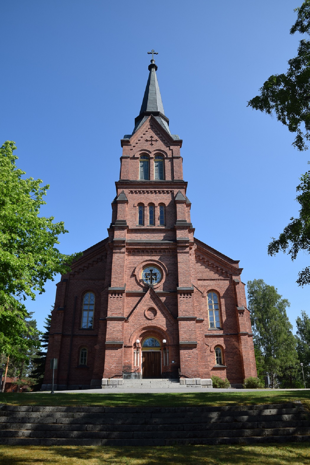 Punatiilinen kirkko pääovelta kuvattuna. 