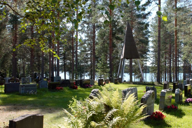 Multianniemen hautausmaa kesäkuva hautakivien takaa pilkistää järvi