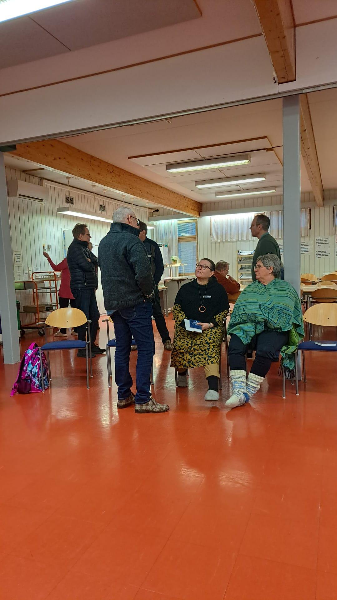 Ihmisiä seisoo ja keskustelee